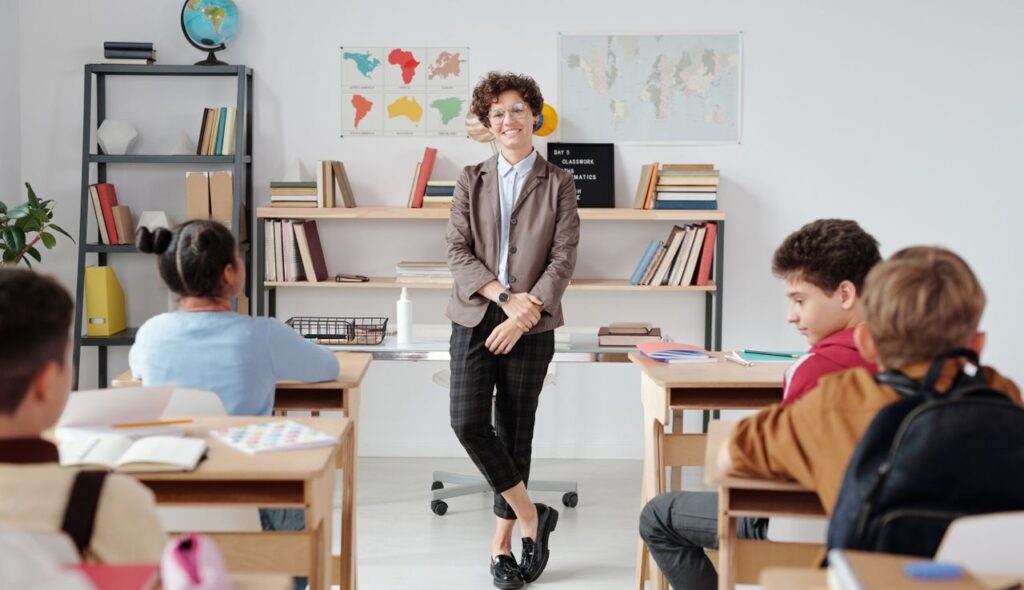 Teacher engaging with diverse students in a modern classroom setting for education.